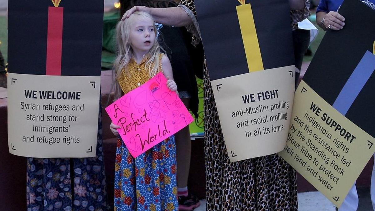 Persephone Nevel, 5, joins a group that gathered on Lincoln Road on Miami Beach on Wednesday, Dec. 21, making a commitment to fighting Islamophobia and racism.