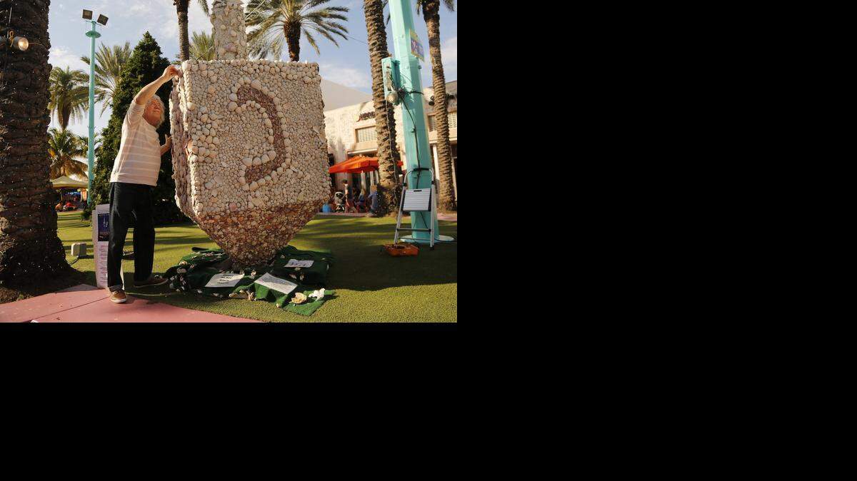 
For the past 13 years, Roger Abramson has been adding seashells to his dreidel and menorah now on display on Lincoln Road.
