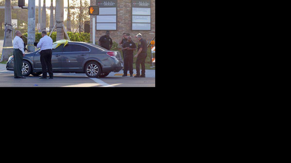 
Miami Gardens Police officers look over an Acura XE at the intersection of NW 27th Ave and 199th St. in Miami Gardens Thursday morning.


