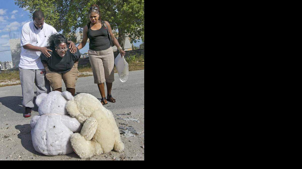 
Catherine Daniels is comforted by her nephew Tyrone Nelson and her cousin Elaine Ingraham Feb. 17, 2015, at a memorial for her son Lavall Hall, 25, who died Feb. 15 after being shot by Miami Gardens police. The family has filed suit against the city and former police chief.
