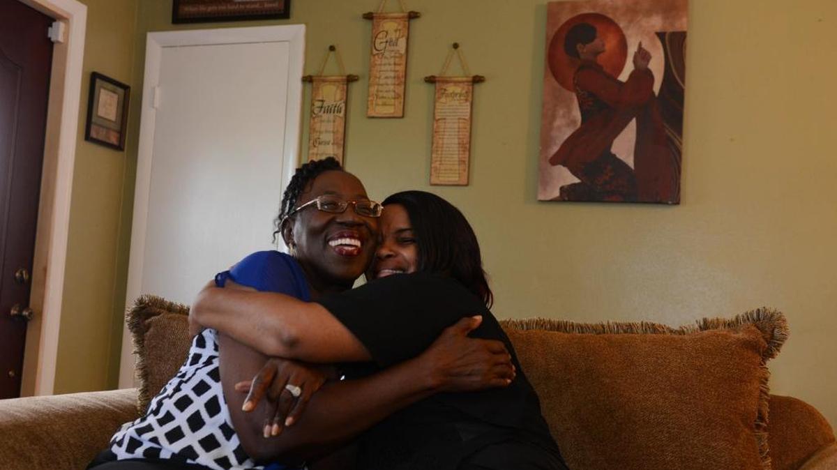 Pastor Etta Hardin embraces Sharon Smith in Smith's Miami Gardens home.