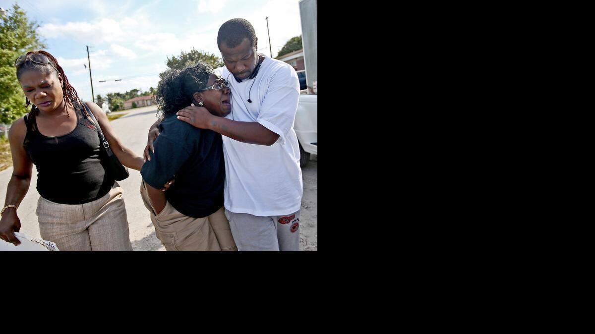 
Catherine Daniels is comforted by her nephew Tyrone Nelson and her cousin Elaine Ingraham at a memorial for her son Lavall Hall in Miami Gardens on Tuesday, Feb. 17, 2015.
