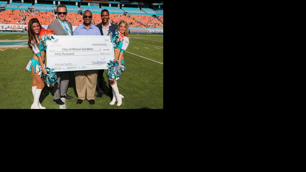 
Tom Garfinkel, Miami Dolphins president and CEO, poses with Miami Gardens Mayor Oliver Gilbert and Twan Russell, Dolphins senior community affairs director. The city received a $50,000 gift from the Dolphins foundation at Sunday’s game to help with park renovations.
