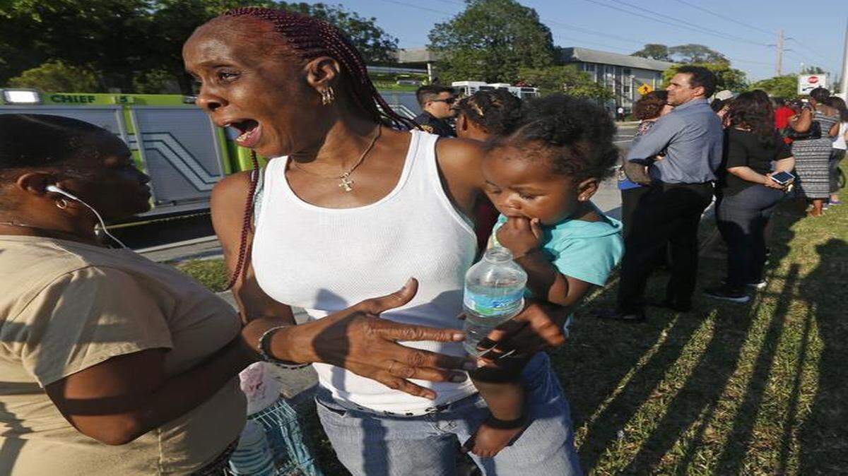 
Juanita Rozier, with her niece Janae Louis, watch firefighters battle a fire in her apartment building in Opa-Locka  on Friday, March 20, 2015.
