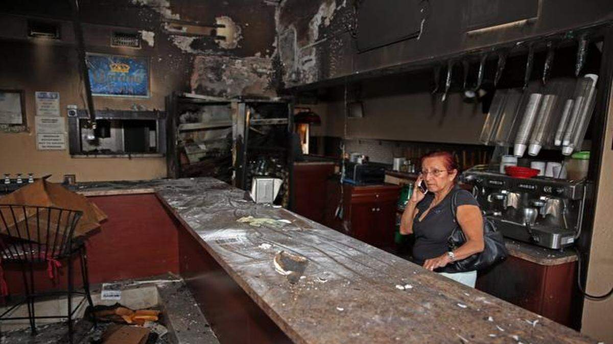 
Ana Mejia, a family member of the owner, looks over damage after beer bottles thrown into Shorty's Cafeteria erupted in flames destroying the Peruvian/Cuban restaurant at 4114 NW 167th St., Wednesday, Dec. 24, 2014.
