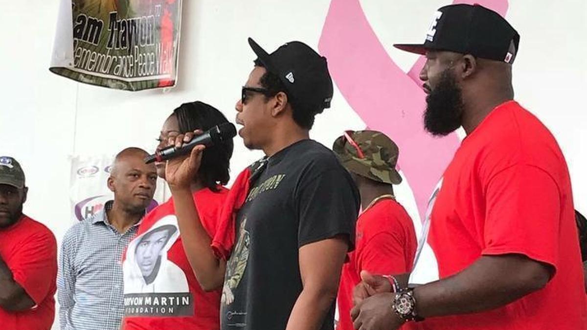 Rapper Shawn “Jay Z” Carter, center, speaks at a Miami Gardens rally, the sixth annual Peace Walk & Peace Talk at the Betty T. Ferguson Amphitheater, to hundreds of marchers and volunteers to honor victims of gun violence, including Trayvon Martin, the Miami Gardens teenager who was shot to death in February 2012 while walking down a street in Sanford, Florida.