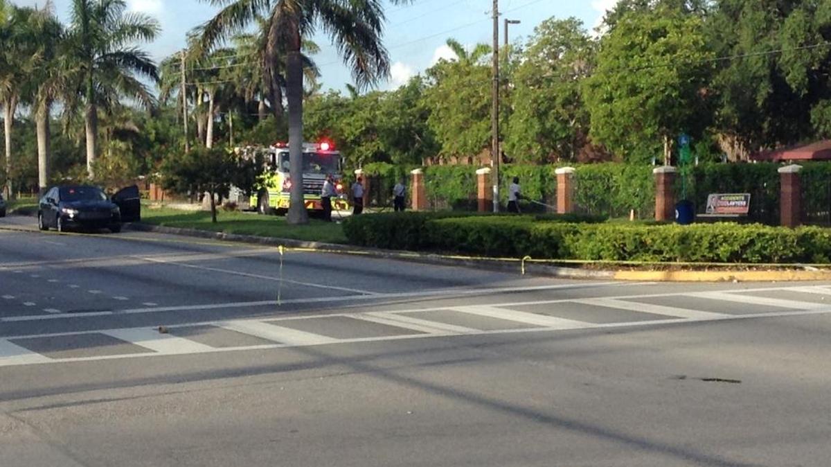 Miami-Dade Fire Rescue cleans up Northwest 22nd Avenue in front of the bus stop bench, site of Monday’s shooting