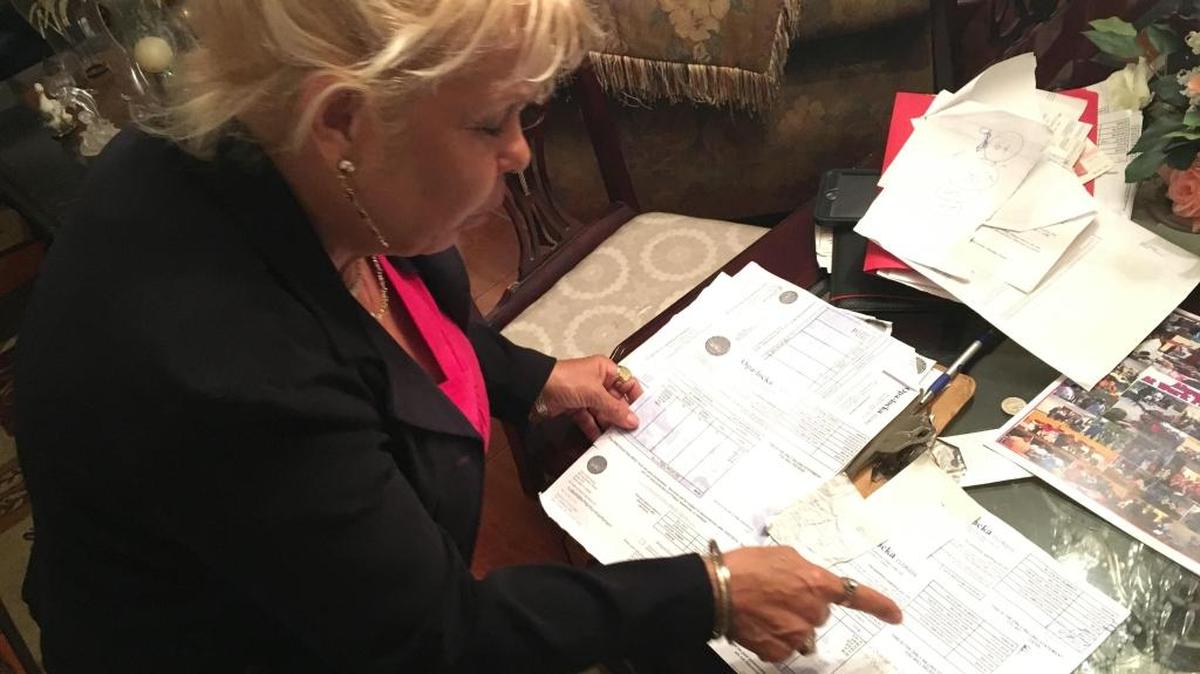 Sandra Collado looks through years of bills, some dating back to 1993, for any irregularities and an explanation to her $500 water bill. Collado took her bill to the Opa-locka commission on Wednesday March 9.