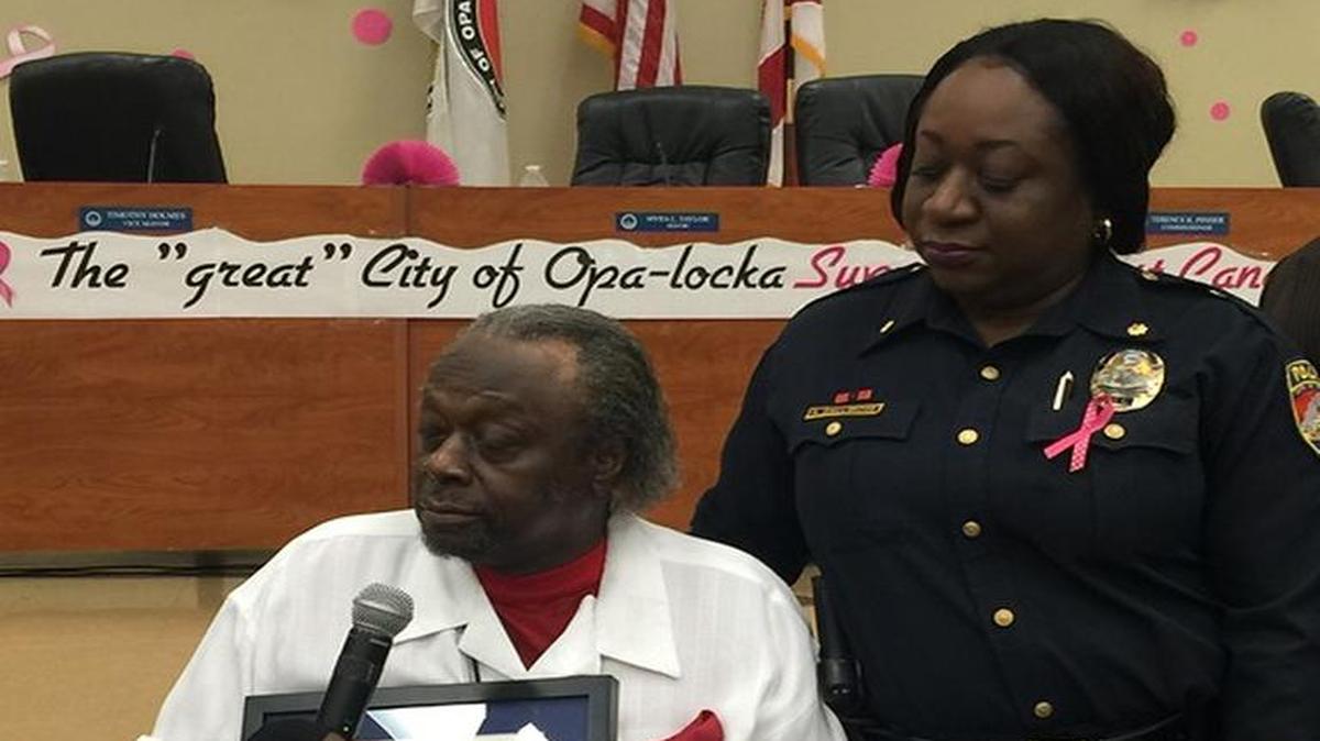 Opa-locka Police Major Sharon Gallimore looks on as her father, Opa-locka Vice Mayor Timothy Holmes, receives the John Land Years of Service Award from the Florida League of Cities on Oct 14.
