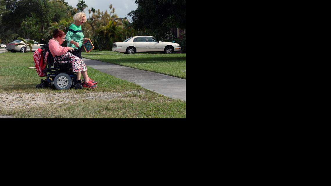 
Helen Gannon, a former Miami Springs city councilwoman, helps her daughter, Debra Ferrero, access a sidewalk in her wheel chair outside her best friend's home.
