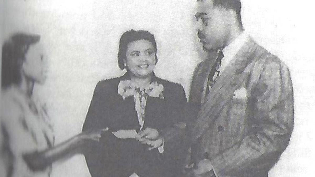 Enid Pinkney and Ireta Crosby, student council sponsor for Booker T. Washington High School, welcome boxer Joe Louis in 1949.