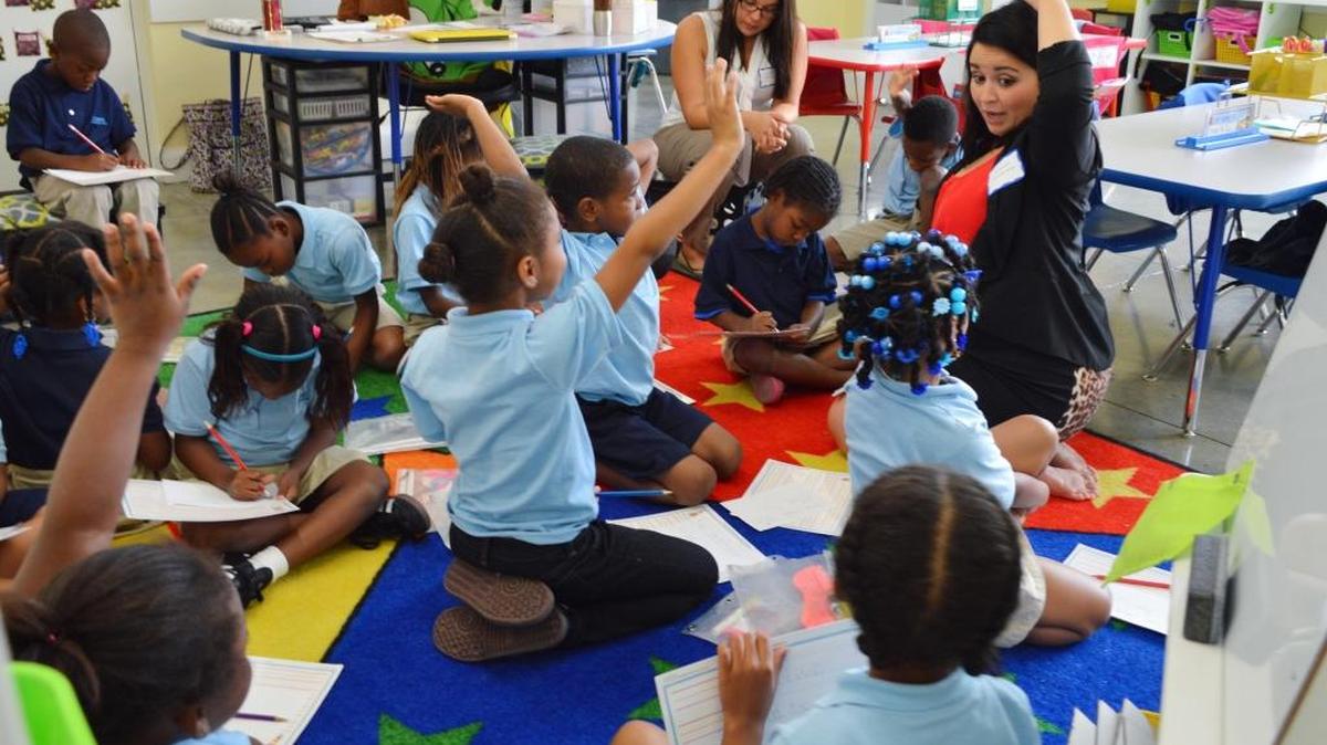 
First grade teacher Carolina Goncalves works with students on reading and pronunciation. 
