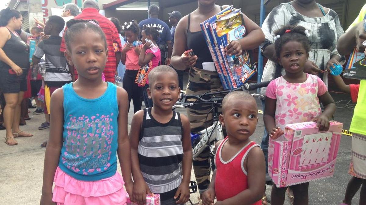 Lunie Prudent and her children with gifts from the Zubi Supermarket toy drive in Little Haiti on Wednesday, Dec. 23.