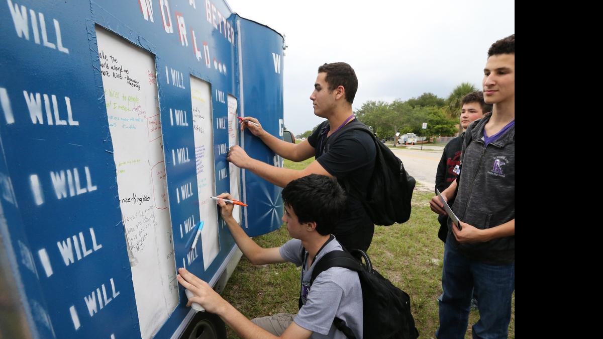 
Mark Itkin and Simon Assouline sign the "I WILL" cloth on the America's Torah RV outside Michael M Krop Sr HS, April 28, 2015. Isroel "Izzy" Labkowski started America's Torah after his father-in-law Rabbi Joseph Raksin was killed as he walked to temple in August. He bought an RV and his touring the country to spread love not hate. They are writing a Torah and asking people to contribute by sponsoring a letter. In addition, they have the "I WILL" cloth where people can write positive messages of what they will do. Labkowski is making a stop at Dr. Michael M. Krop Senior High to speak with the Chabad club there.

