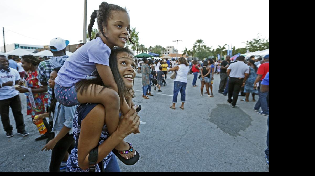 
Daphney Souriac carries her daughter Ariel Souriac, 4, during the third annual Taste of Haiti at MOCA Plaza on Saturday, May 9, 2015.
