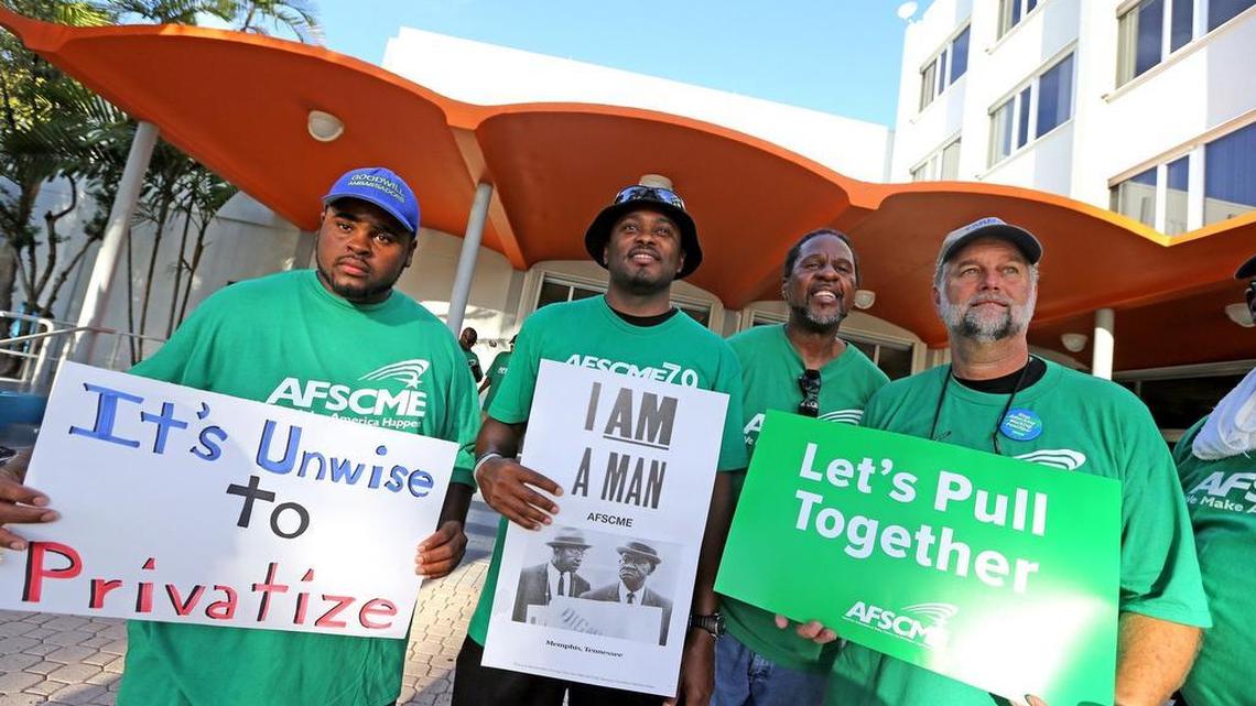 Sanitation workers Malcom Cobb, Mario Roberts, Perman Terry and Jim Wickett carry protest signs as they gather for a North Miami Beach council meeting Tuesday, Aug. 4, 2015. The sanitation workers planned to speak out against North Miami Beach's proposal to outsource its sanitation services.
