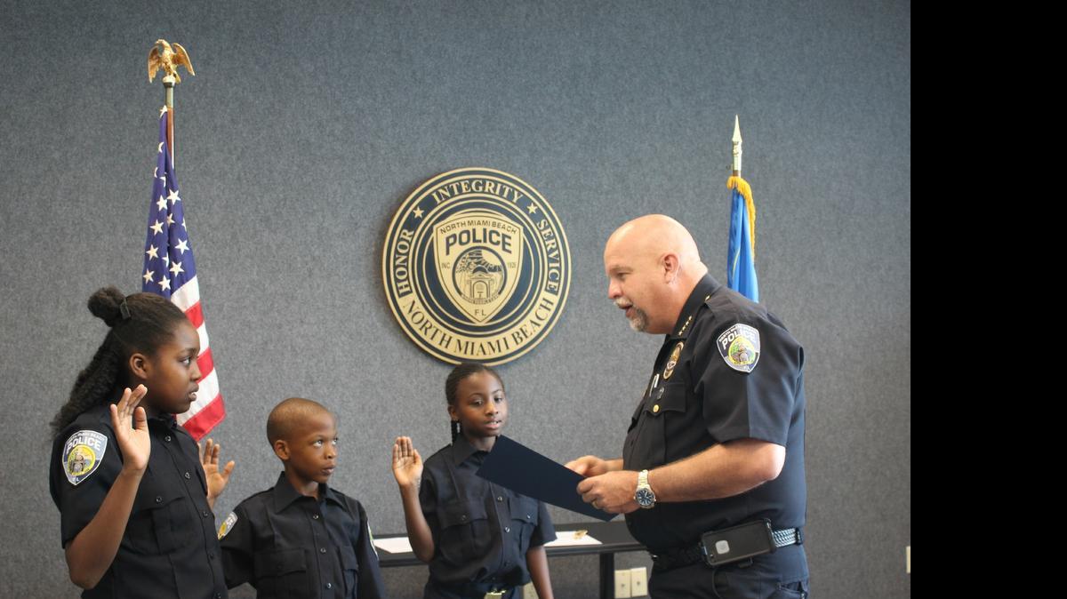 
Christie Baptiste, 11, Kenold Ordenat, 9, and Nae’kia Lawrence, 9, are sworn in as “Jr. Police Chiefs for a day” by Police Chief Scott Dennis 
