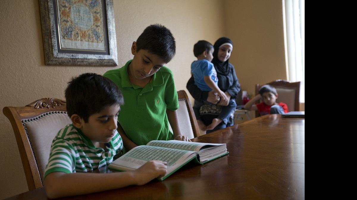 
Brothers Dayaan Shah 10 (right), and Amaan Shah 11, read the Quran at home on Wednesday, July 15, 2015. The young men have taken part in their first month-long fast of Ramadan. Friday is the Eid al-Fitr , which marks the end of the month-long fast of Ramadan. The boys’ mother Faika Shah, holding 4 year-old brother Zayaan, while brother Faizan 7, look on.
