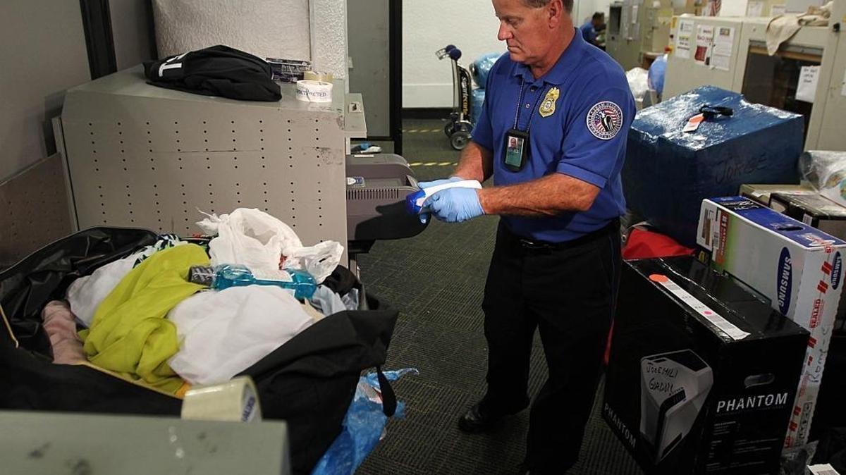 A TSA agent checks luggage at Miami International Airport.