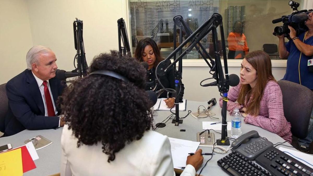 Mayor Carlos Gimenez, left and School Board member Raquel Regalado, right, field questions from moderators Jessica Modkins (an advertising executive with her back to the camera) and Miami Times editor Carolyn Guniss, center.