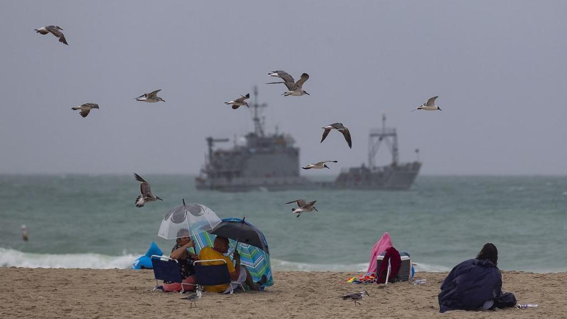 Visitors place umbrellas and try to stay dry as they attend the Hyundai Air & Sea Show in Miami Beach on Saturday, May 26, 2018.