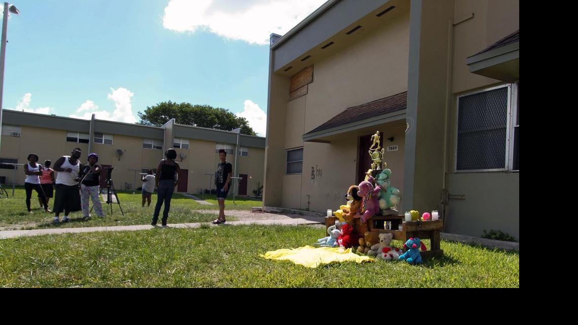 
Onlookers gather near a makeshift memorial where a 15-year-old Miami Northwestern Senior High freshman was shot dead and four others were wounded at Northwest 75th Street and 16th Avenue Monday night.
