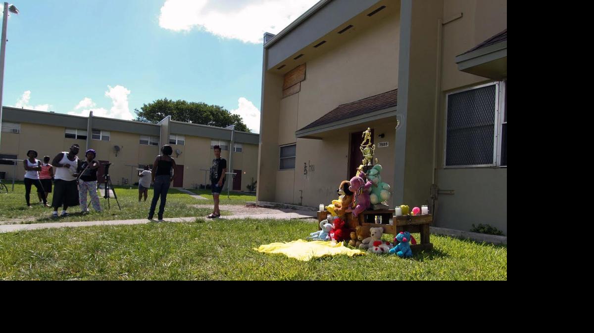 
Onlookers gather near a makeshift memorial where a 15-year-old Miami Northwestern Senior High freshman was shot dead and four others were wounded at Northwest 75th Street and 16th Avenue Monday night.
