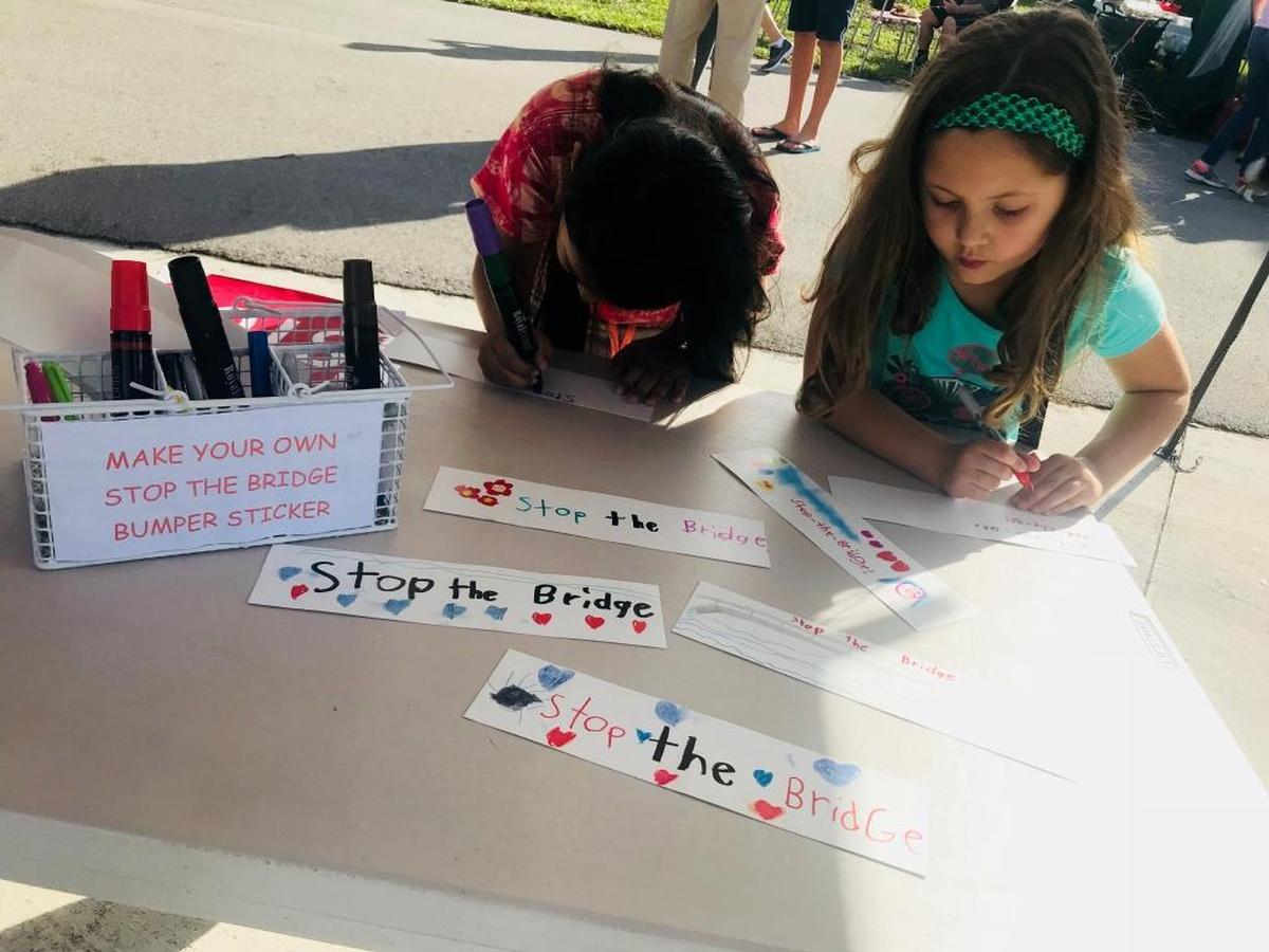 Will building a bridge over 87th Avenue be the answer to drivers’ traffic headaches? A block party was held Sunday to oppose the idea. Pictured from left to right are: Andrea Anido, 7, and Mia Puente, 6.