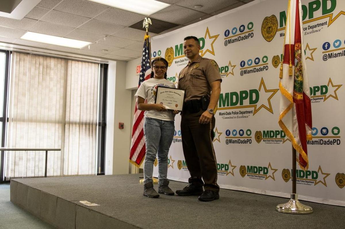 Miami-Dade Police Assistant Director Freddy Ramirez presents a certificate to Destiny Hall for her participation in the department’s first Teen Citizen's Police Academy program at the department’s headquarters in Doral on Friday, Aug. 18, 2017.