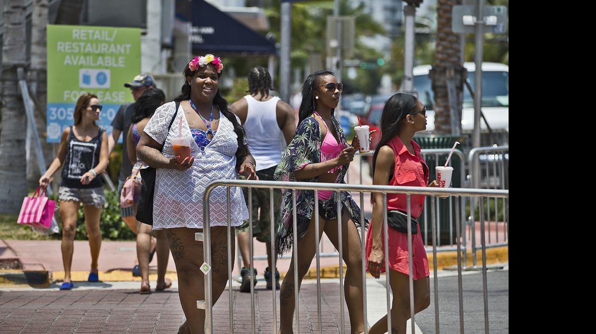 
FLOCKING TO THE BEACHES: A group of tourist from Philadelphia cross Collins Avenue in Miami Beach on Thursday, May 21, 2015, as the area prepared for the busy Memorial Day weekend.
