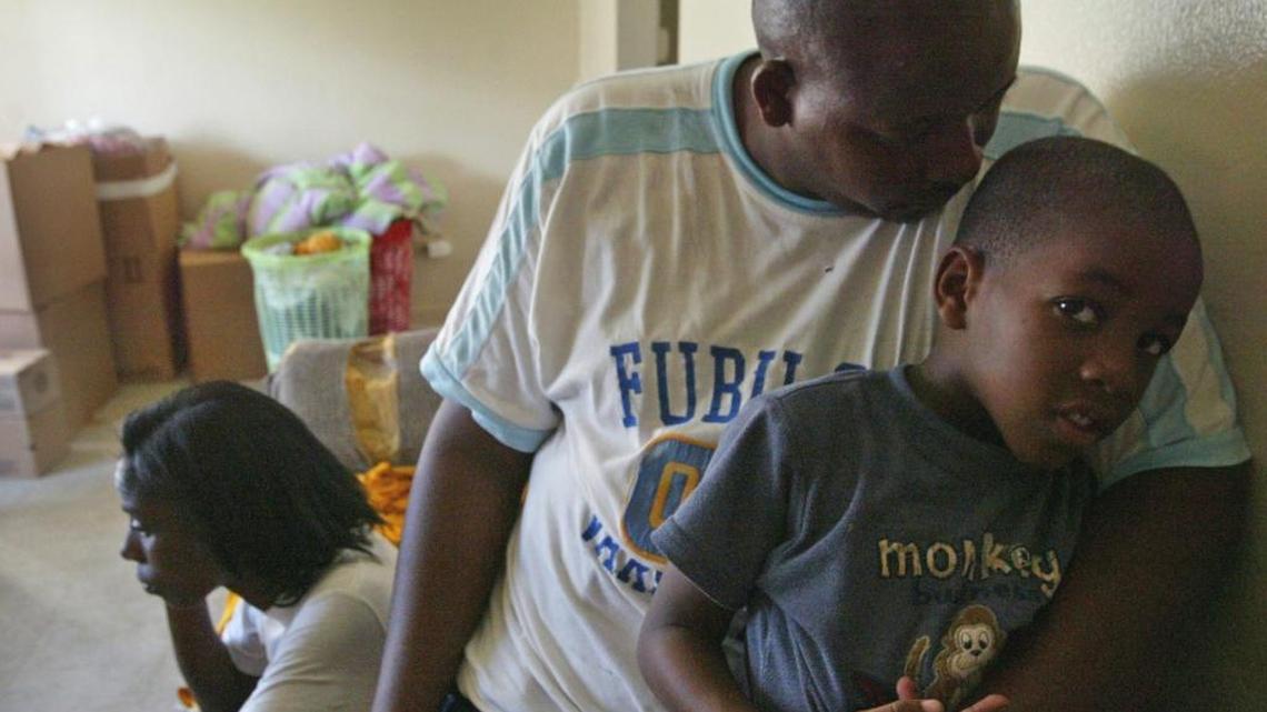 Sherron Jenkins and David Jenkins, holding their son David,4, sit in the living room area of the apartment where Sherdavia Jenkins,9, bled to death from a gunshot wound after getting shot while playing in the front of the house.