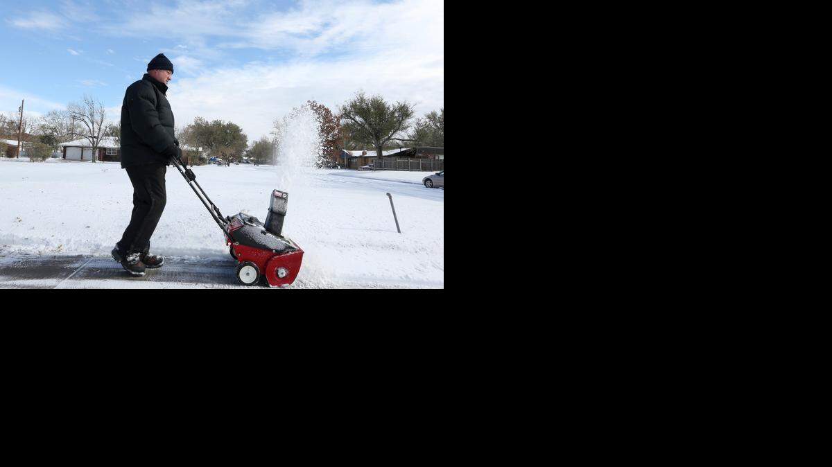 
South Florida will not looklike Wichita, Kansas, on Sunday, with Chester Kralicek clearing snow from a sidewalk. 


