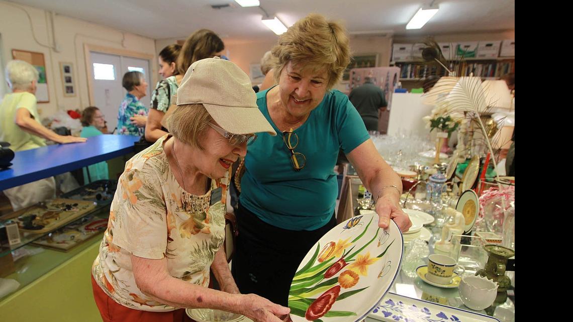
Plate du jour: Margaret Land, left, and Barbara Hellman look at a piece of serviceware at the Ruth Kinsman Thrift Shop in Cutler Bay. 
