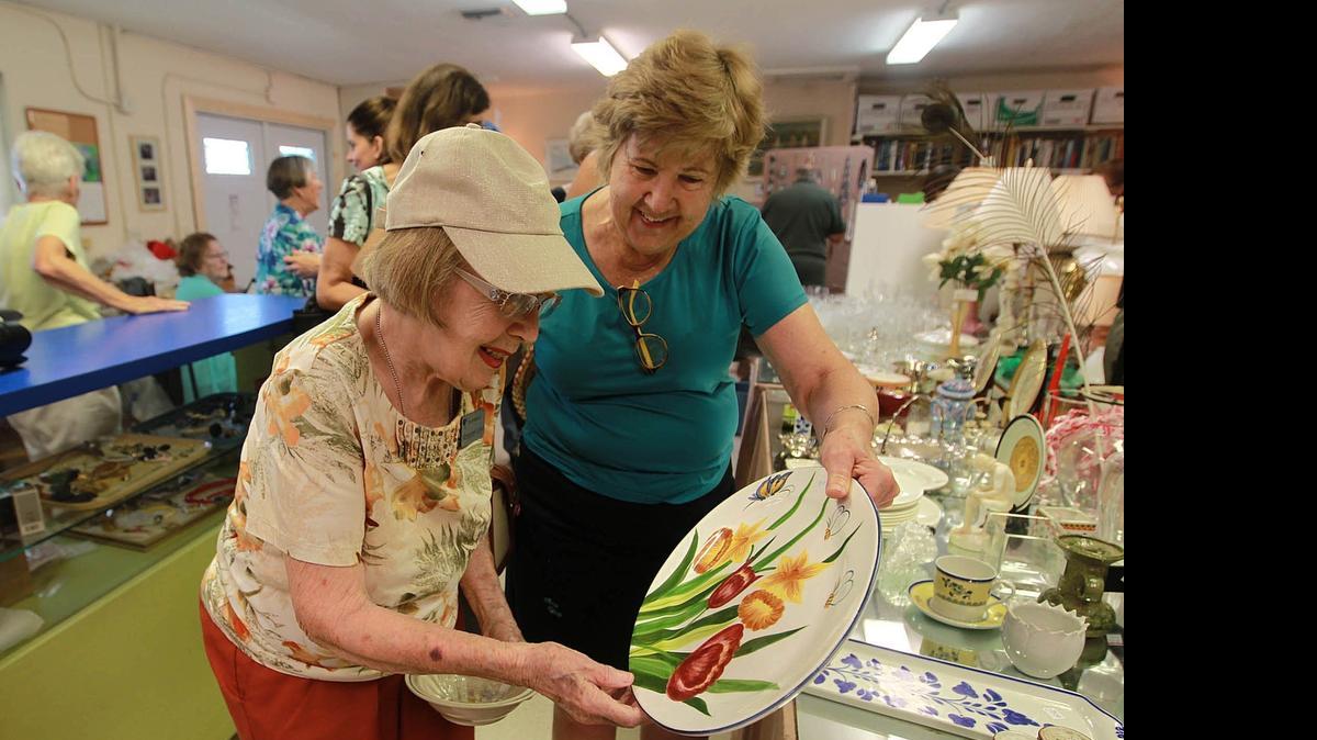 
Plate du jour: Margaret Land, left, and Barbara Hellman look at a piece of serviceware at the Ruth Kinsman Thrift Shop in Cutler Bay. 
