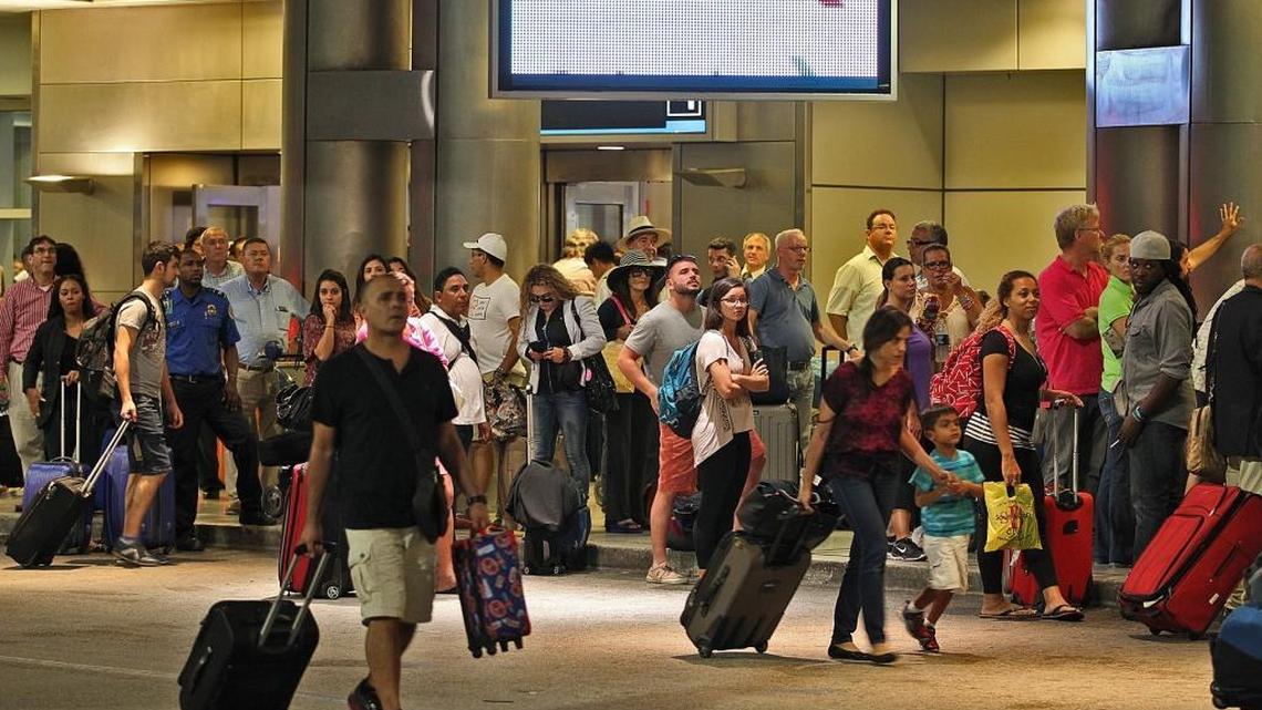 Crowds wait to be let back into Miami International Airport after an evacuation on Monday, Nov. 9, 2015.