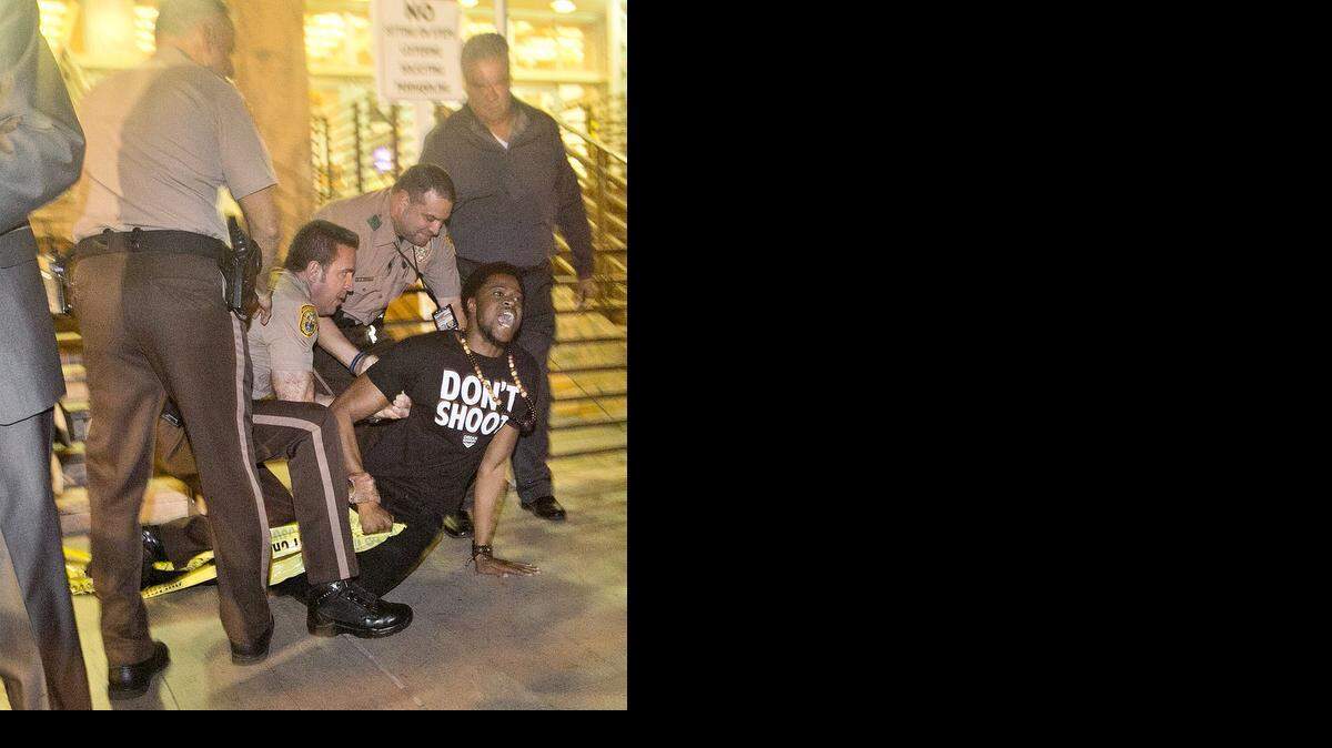 
Jeremy Shaw, 25, is arrested on the steps of the Gerstein Justice Building in downtown Miami on Tuesday, Nov. 25, 2014, at a Ferguson rally.
