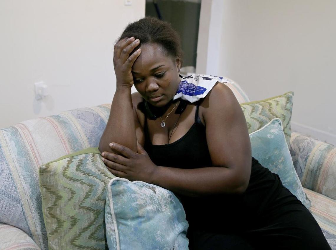 Luce Rameau reacts after escaping with only minor injuries after a raft fell through the roof of her northeast Miami home from a Royal Canadian Air Force helicopter on its way back to Miami-Opa locka Executive Airport on Feb. 28, 2018.