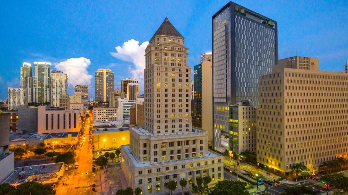 A rendering of how the proposed Miami-Dade courthouse tower would look next to its replacement in downtown Miami. The courthouse proposed by developer Russell Galbut is the tallest building to the right, and the existing courthouse, with a pointed roof, is in the center. Architect Kobi Karp created the design.