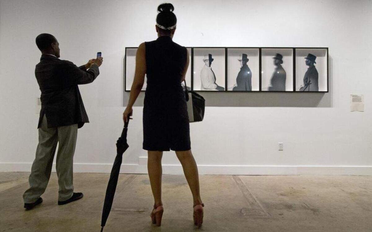 Patrons view an installation titled Zero Hour by artist Hank Willis Thomas on display during the fourth annual Art of Transformation Exhibit in Opa-locka in 2015. Planners of a new museum featuring contemporary art of the African Diaspora hope to feature artists like Thomas and others in a facility in Northwest Miami-Dade.