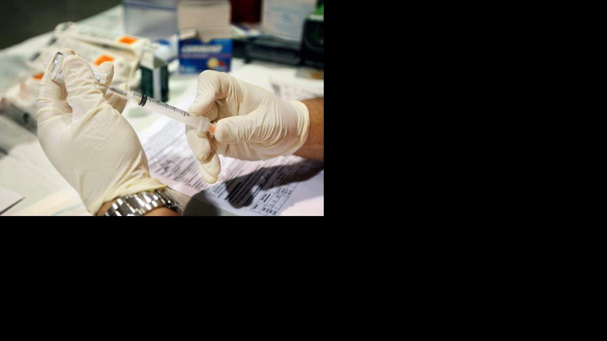 
A nurse prepares a flu vaccination shot at a health fair in Miami-Dade County in 2009. 
