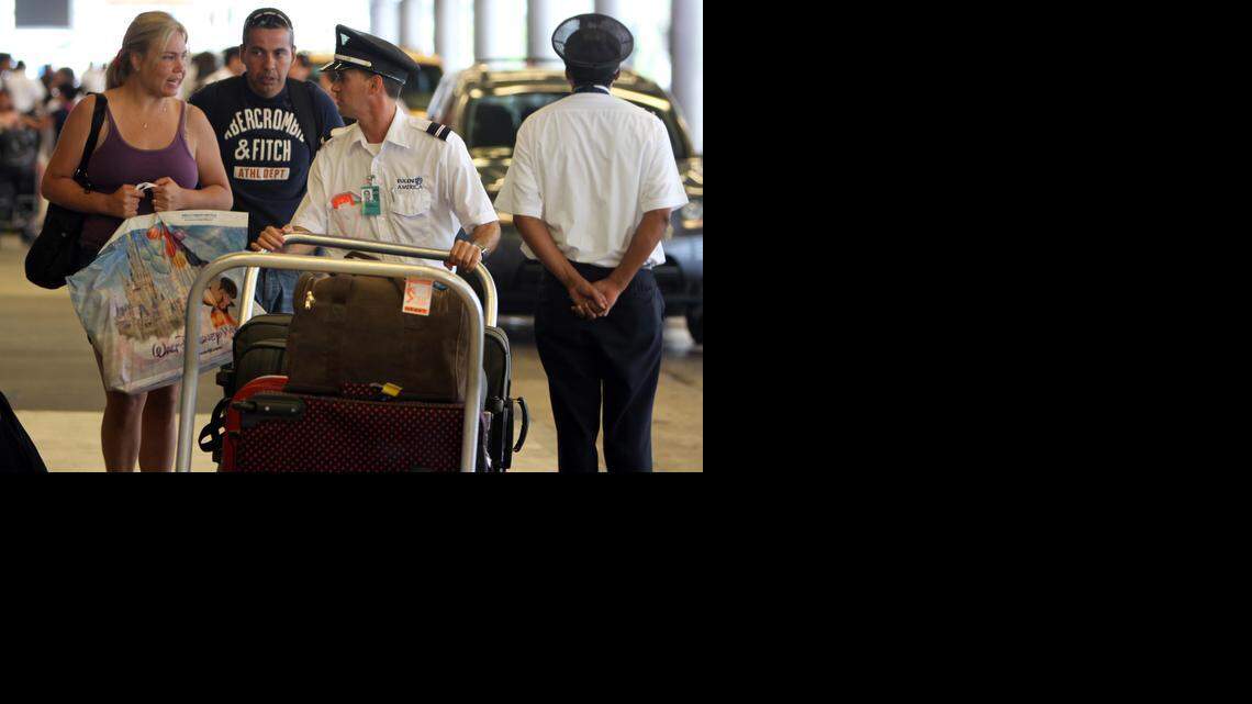 
A Eulen America employee helps passengers with their bags at Miami International Airport in 2010.

