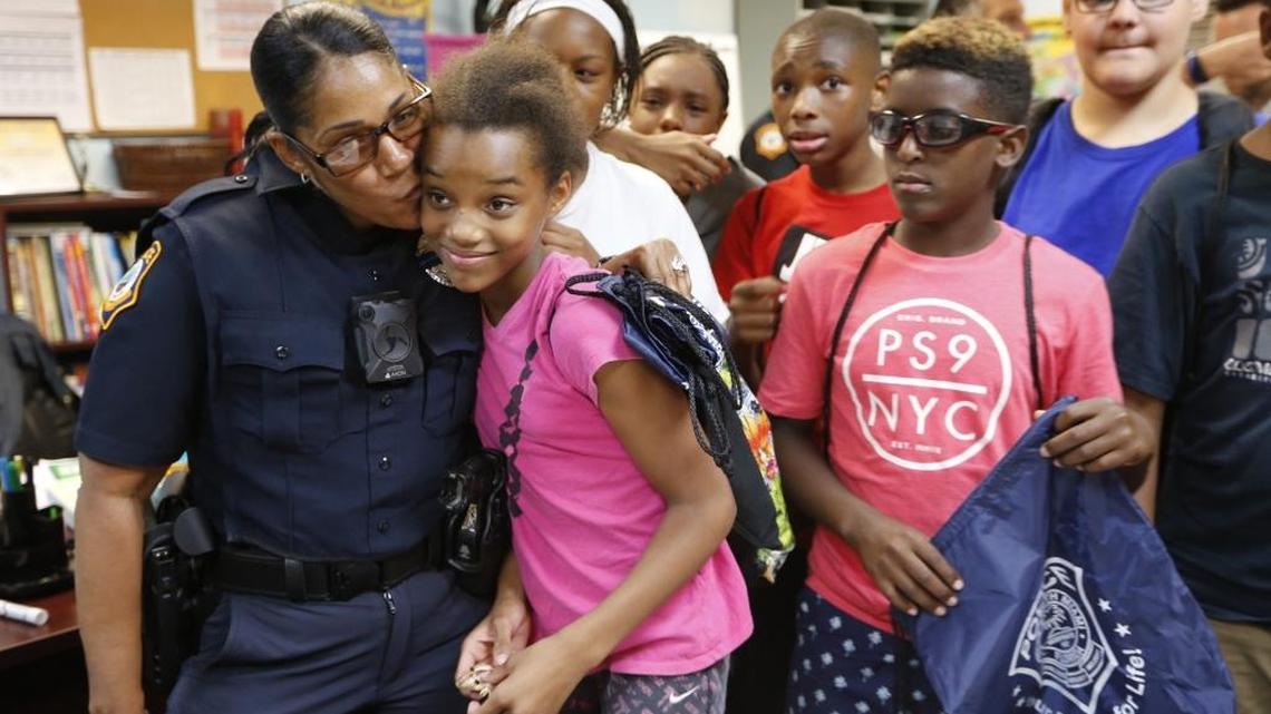 South Miami Police and Community Resource Officer Melvris Lopez kisses Laniyah Leon, 12, on July 14 as the police department kicks off its second annual C.A.S.T. (Cops and Students Talking) program.