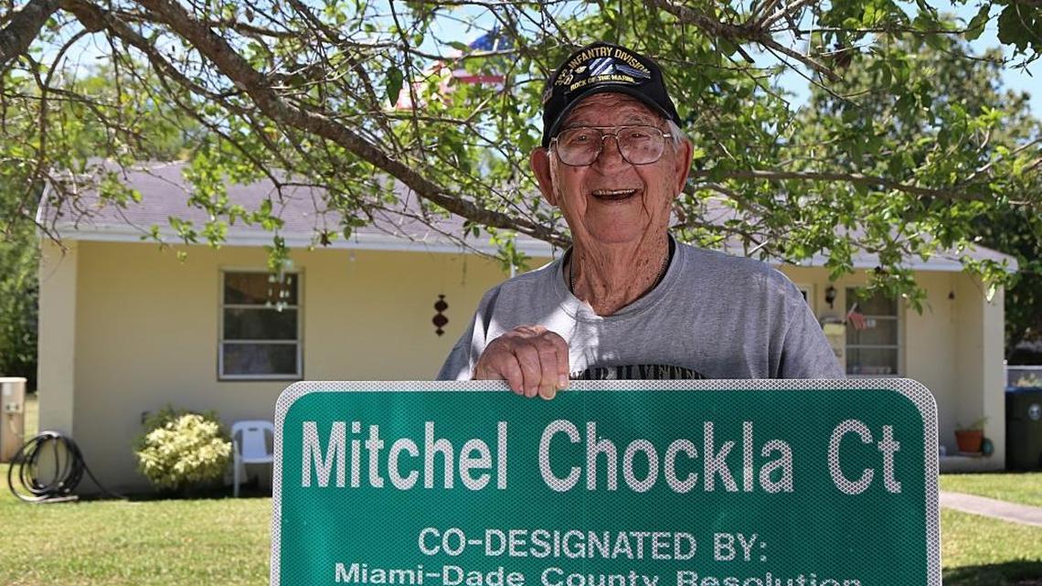 World War II veteran Mitchel Chockla, now 96, in front of his house on April 7, 2017, holding a street sign designated in his name by Miami-Dade County and the city of South Miami. He moved into South Miami with his family in 1951. He’s considered one of the last original homeowners in South Miami.