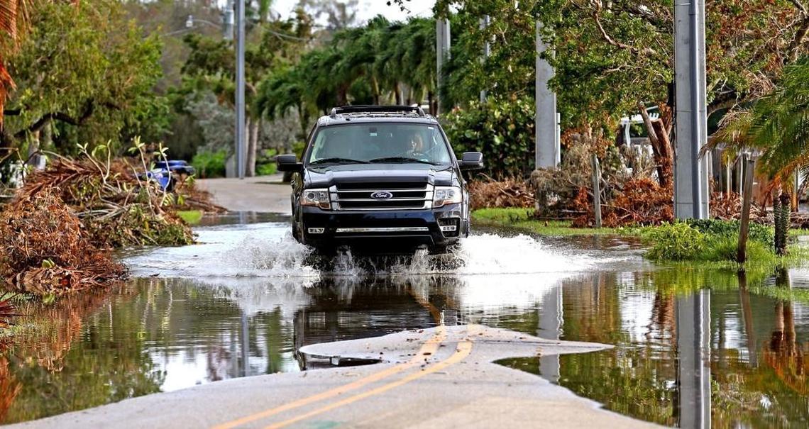 A car drives through water on the street as the King Tide rises on Cordova Road in Fort Lauderdale, Tuesday, Sept. 19, 2017. The King Tide has worsened in the last several years flooding streets and yards in the lower elevations in South Florida.