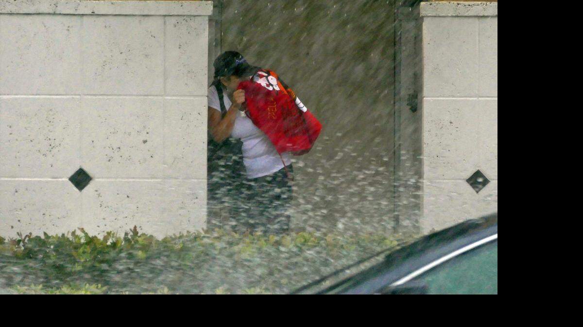 
A woman waits for a bus in a downpour on Northeast 125th Street just east of Biscayne Boulevard. Tuesday April 21, 2015.

