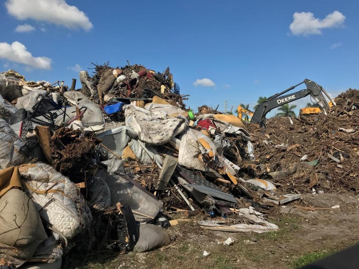 The streetside view of a storm-debris yard that infuriated nearby residents of a Liberty City apartment complex. Miami-Dade County established the dump after Hurricane Irma, but has decided to close it to new truck shipments after residents complained.