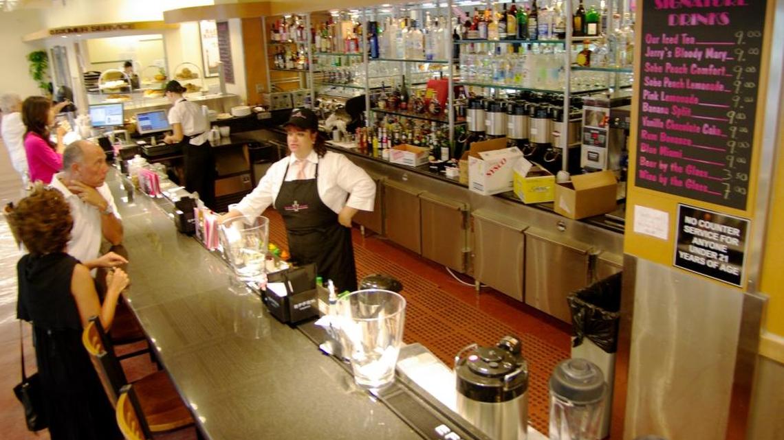 In this 2008 photo of Epicure Gourmet Market & Cafe in Sunny Isles Beach, a bartender serves cocktails at an inside bar. The market will close its Sunny Isles Beach location later this month, leaving only the original Epicure Market on Alton Road in Miami Beach.