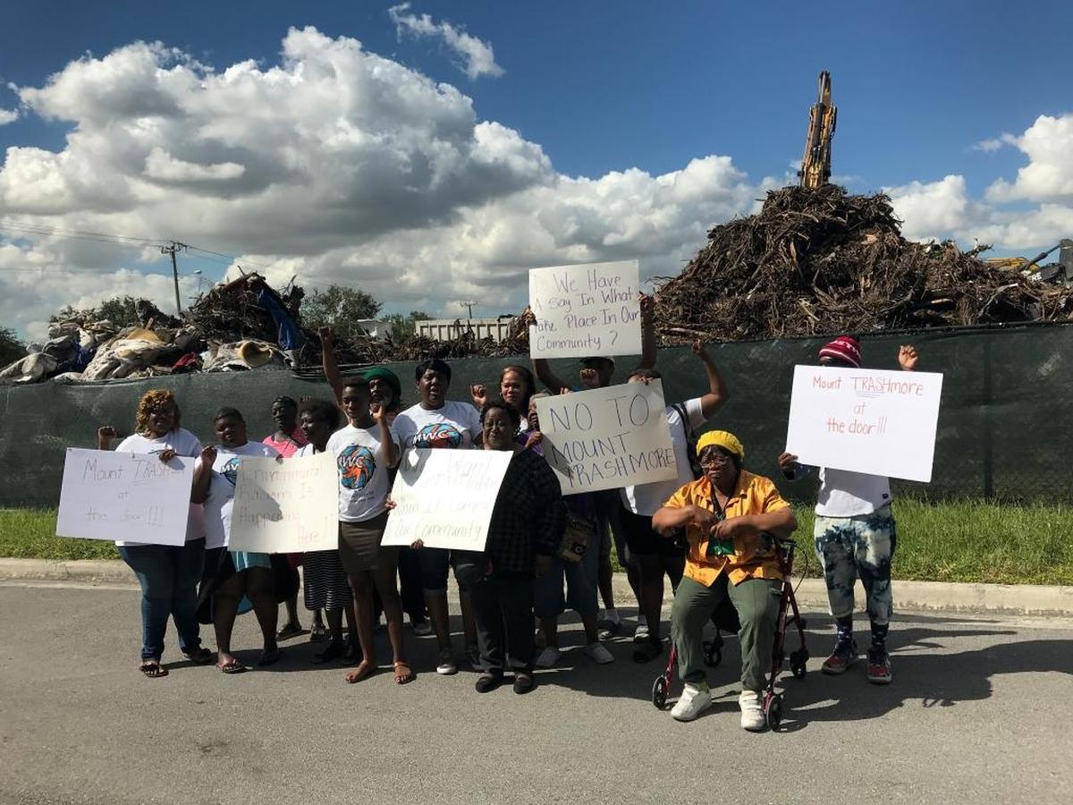 Helen Clarke, seated, joins protestors of a county storm-debris dump Miami-Dade in the Liberty City neighborhood, across the street from the Northpark at Scott Carver apartment complex.