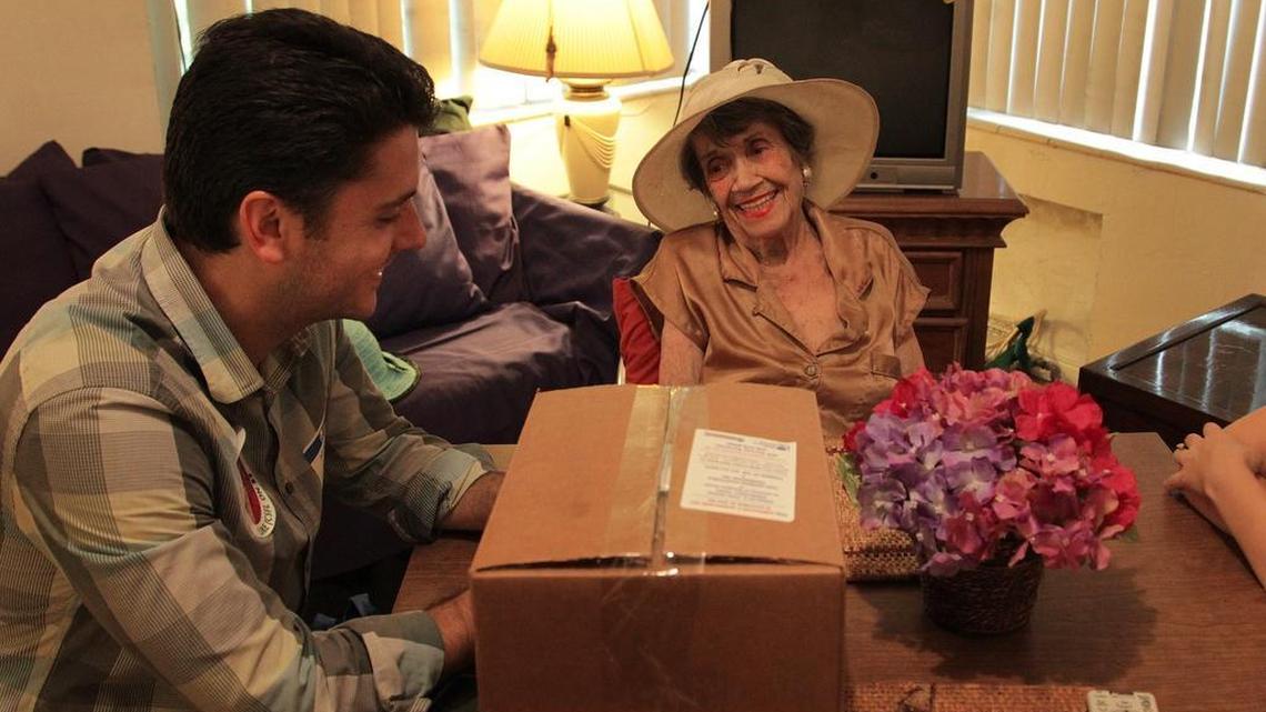 
Spending quality time: Volunteer Michael Levine visits with Belle Thweny, 93, as while delivering a food basket to her.


