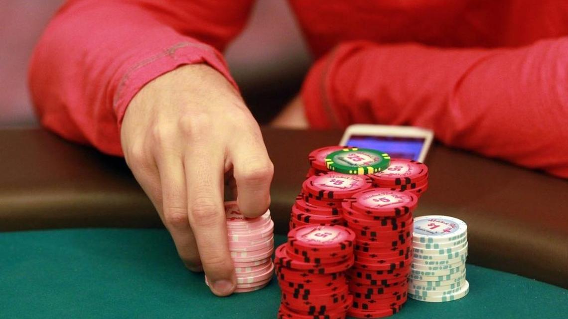 A player holds his chips while playing poker at Hialeah Park.